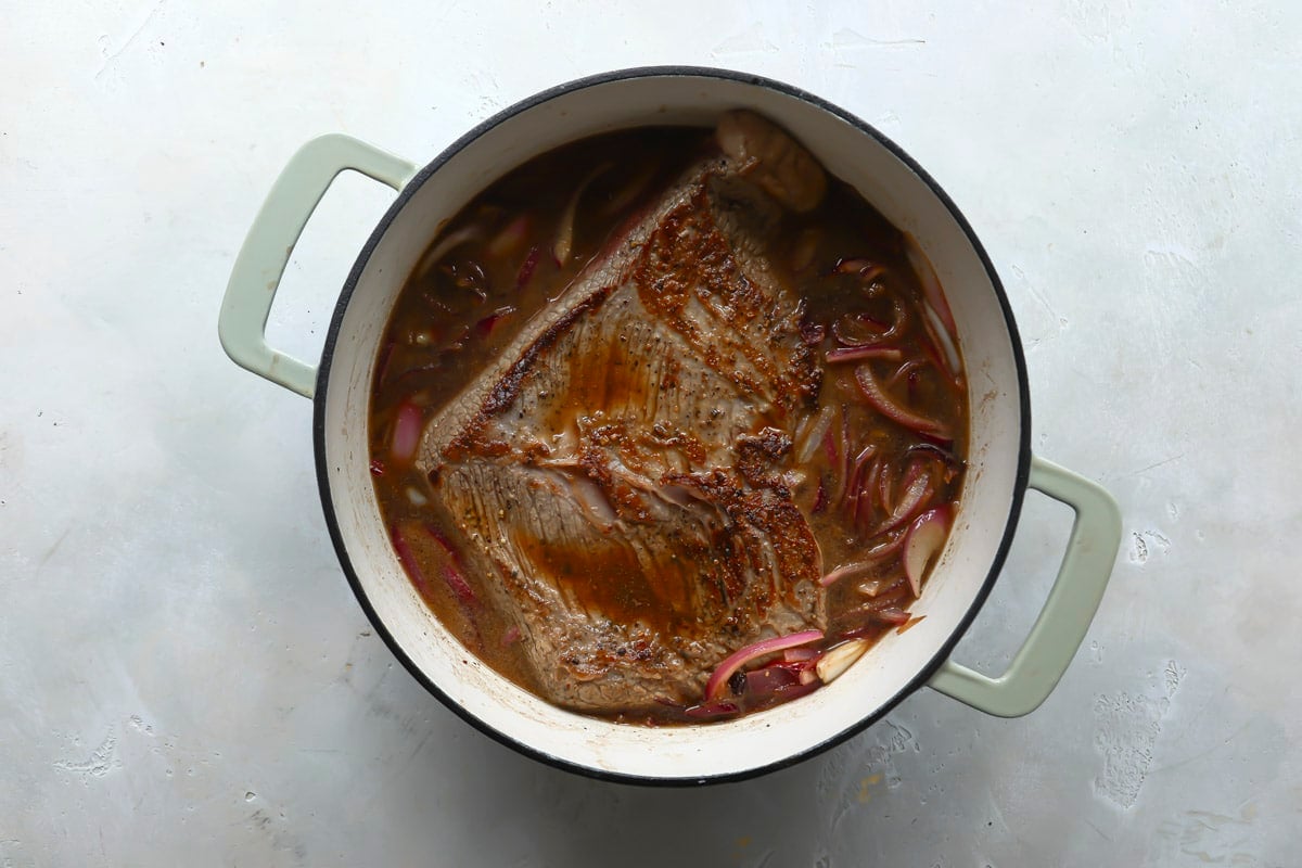 Braised beef brisket in a Dutch oven.
