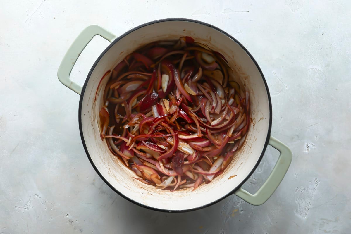 Onion, garlic and bay leafs in a Dutch oven.