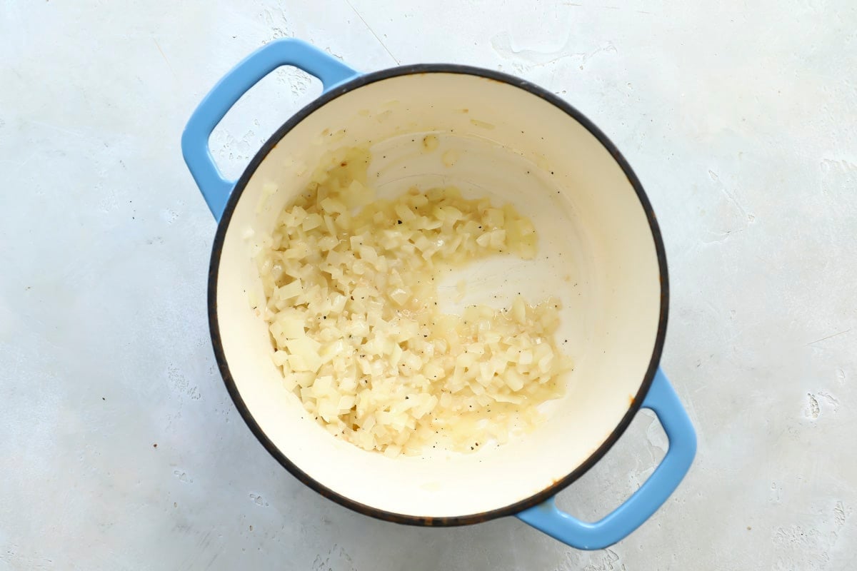 Onion and butter cooking in a Dutch oven.