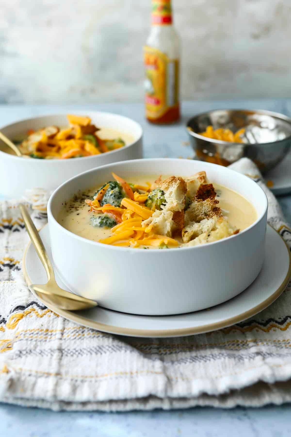 Broccoli cheese soup garnished with croutons and cheese.