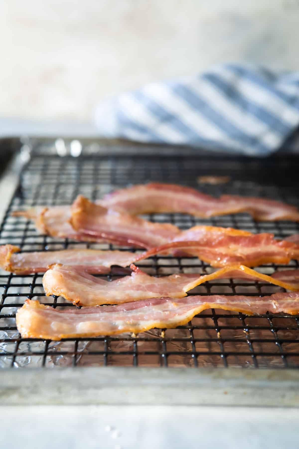 Cooked bacon on a rack set over a foil-lined baking sheet.