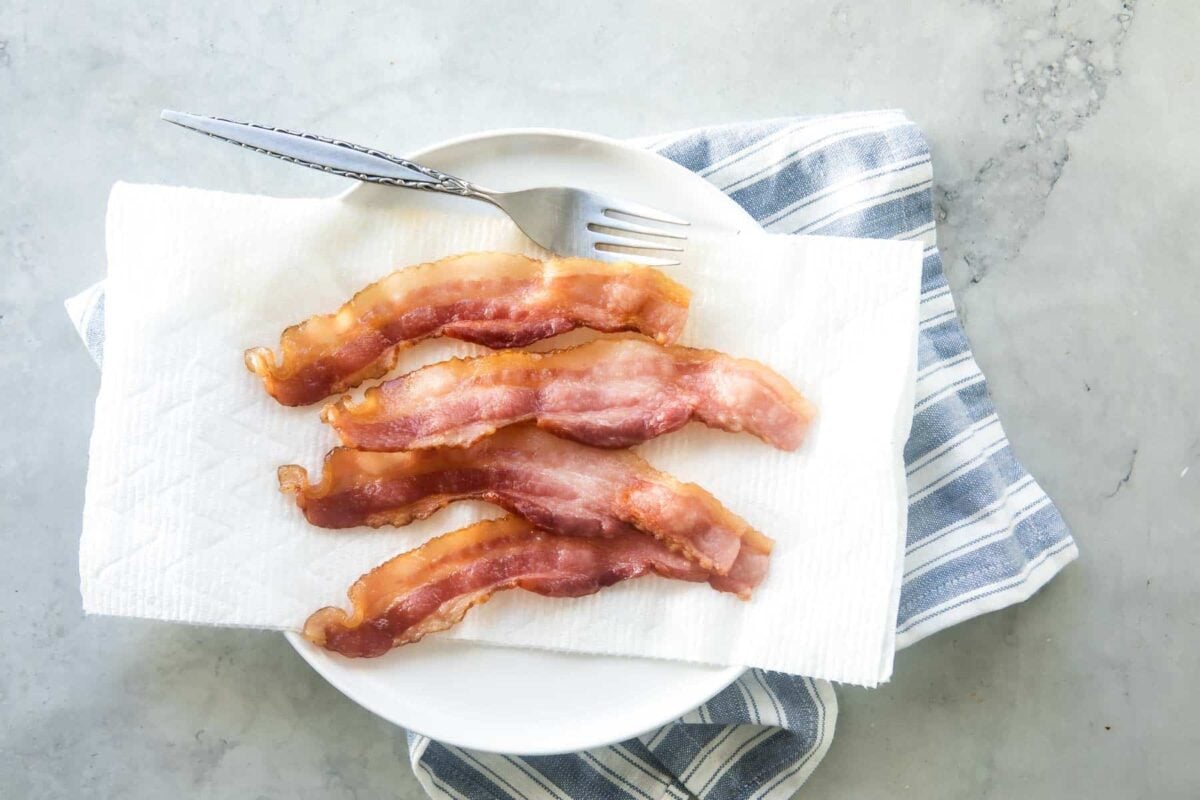 Cooked bacon draining on paper towels.