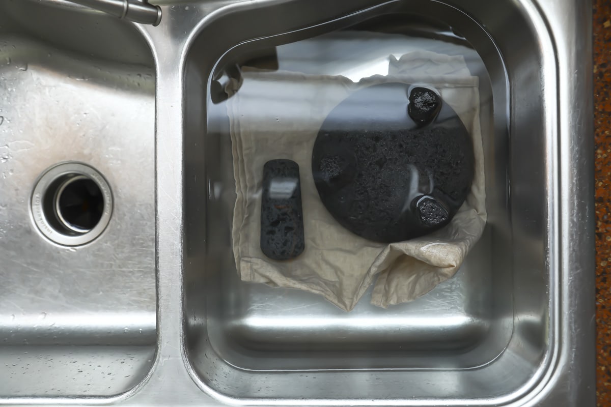 A molcajete and root brush in a sink.