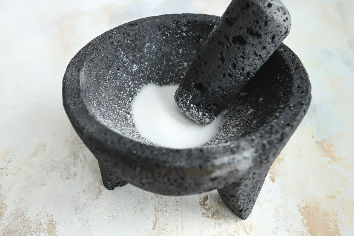 Grinding salt in a molcajete to clean it.