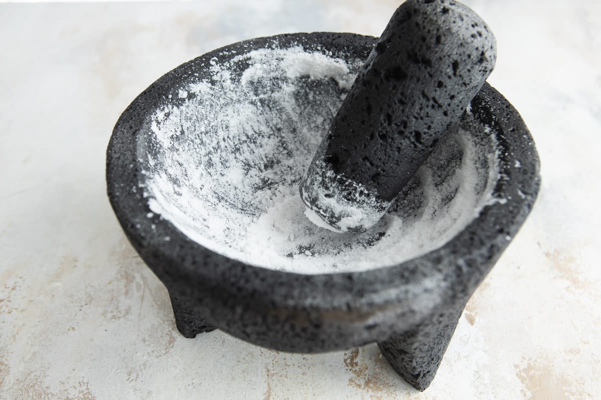 Grinding salt in a molcajete to clean it.