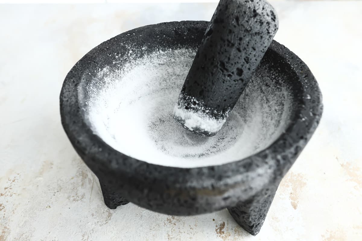 Grinding salt in a molcajete to clean it.