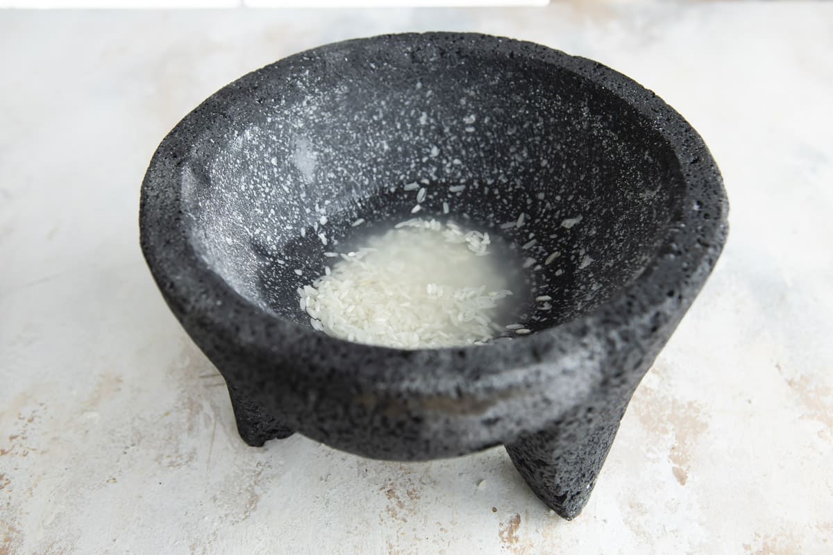 Grinding salt in a molcajete to clean it.