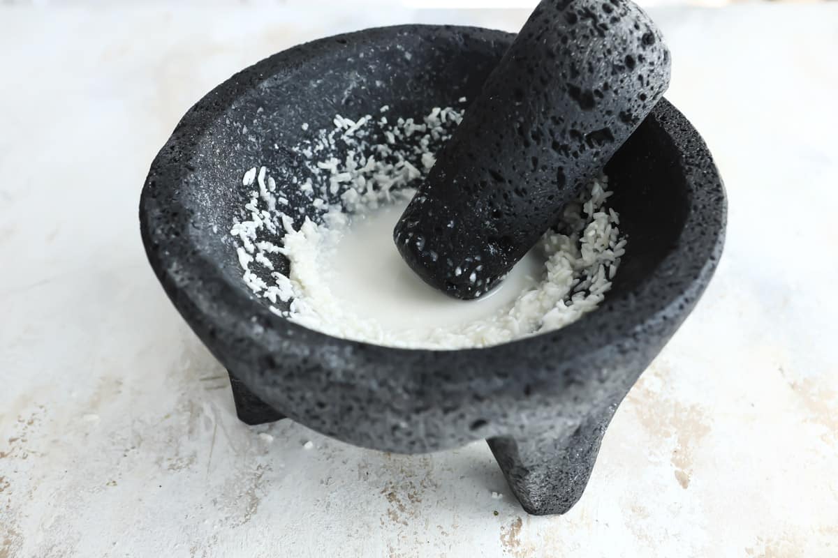 Grinding salt in a molcajete to clean it.