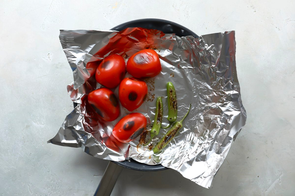 Roasted tomatoes and chiles in a skillet.