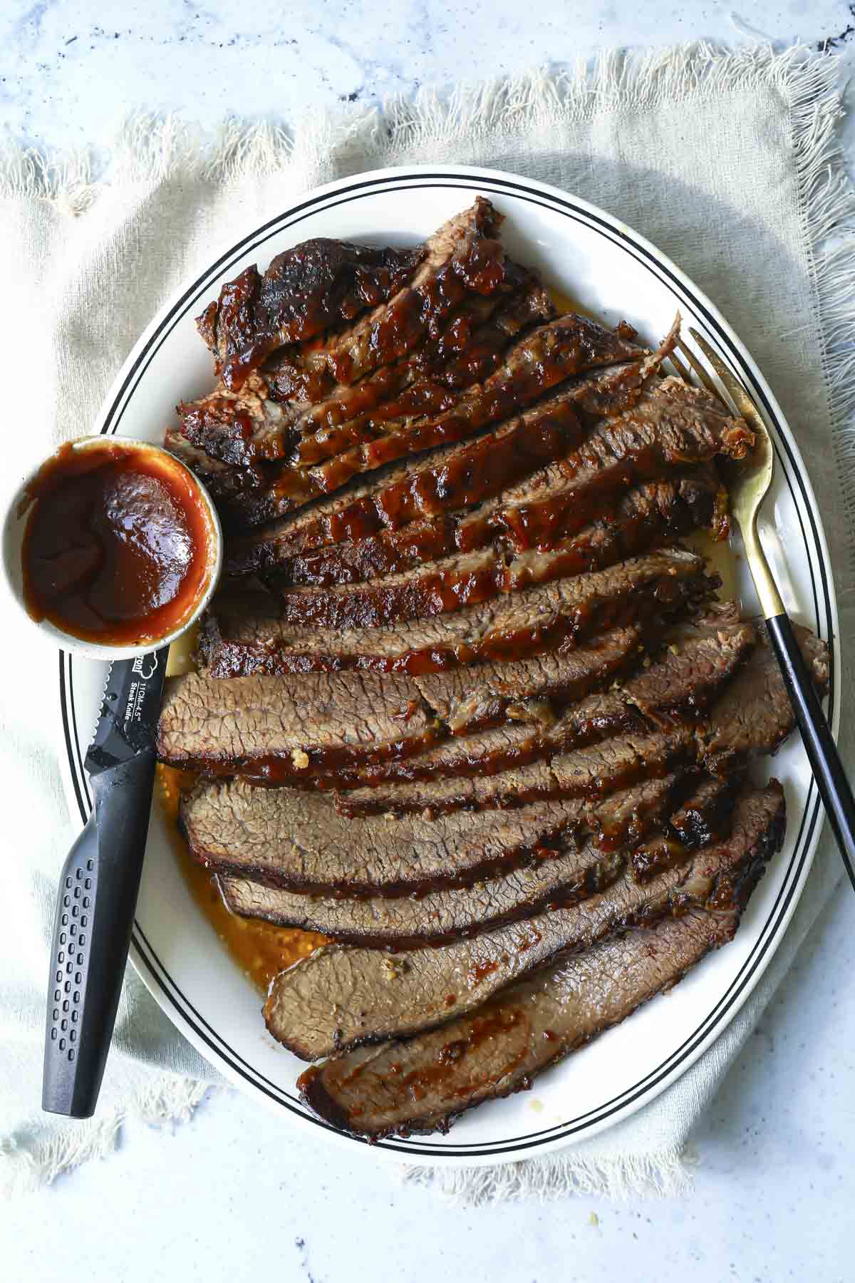 A serving platter with a slow cooker beef brisket slices.