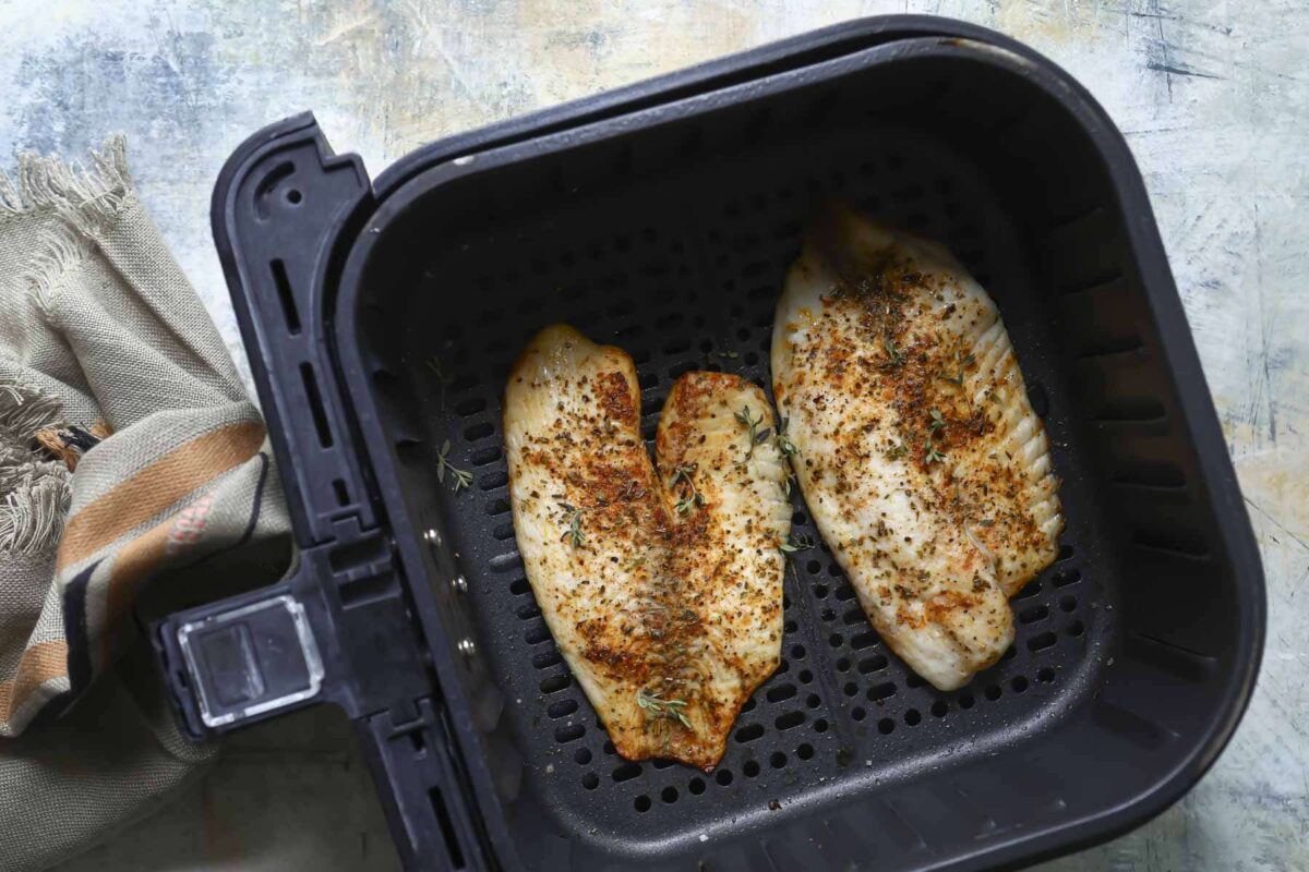Tilapia in an air fryer basket.
