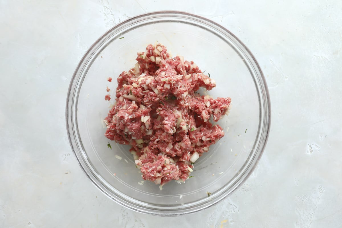 Meat mixture for albondigas soup in a glass bowl.