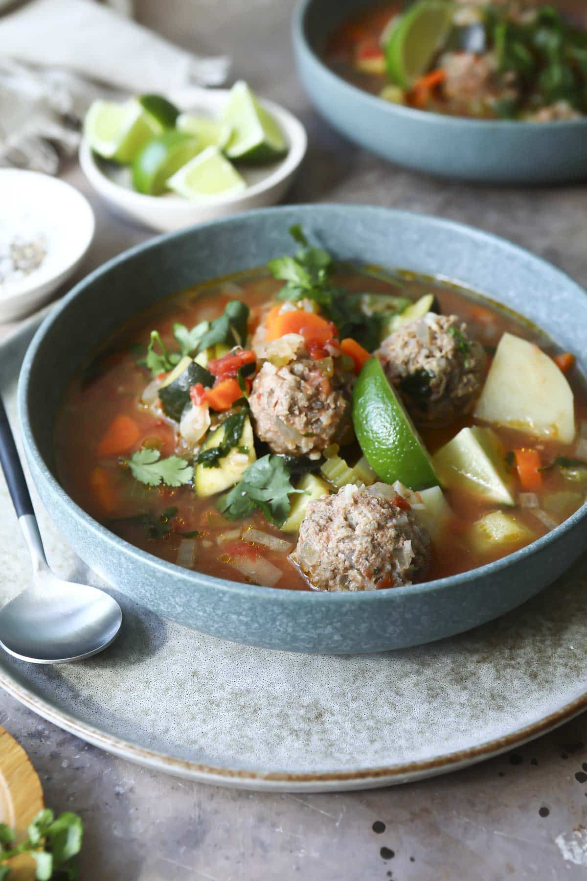 Two blue bowls of Albondigas soup.