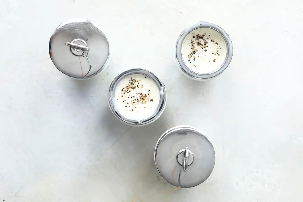 4 egg coddlers with eggs and cream inside.