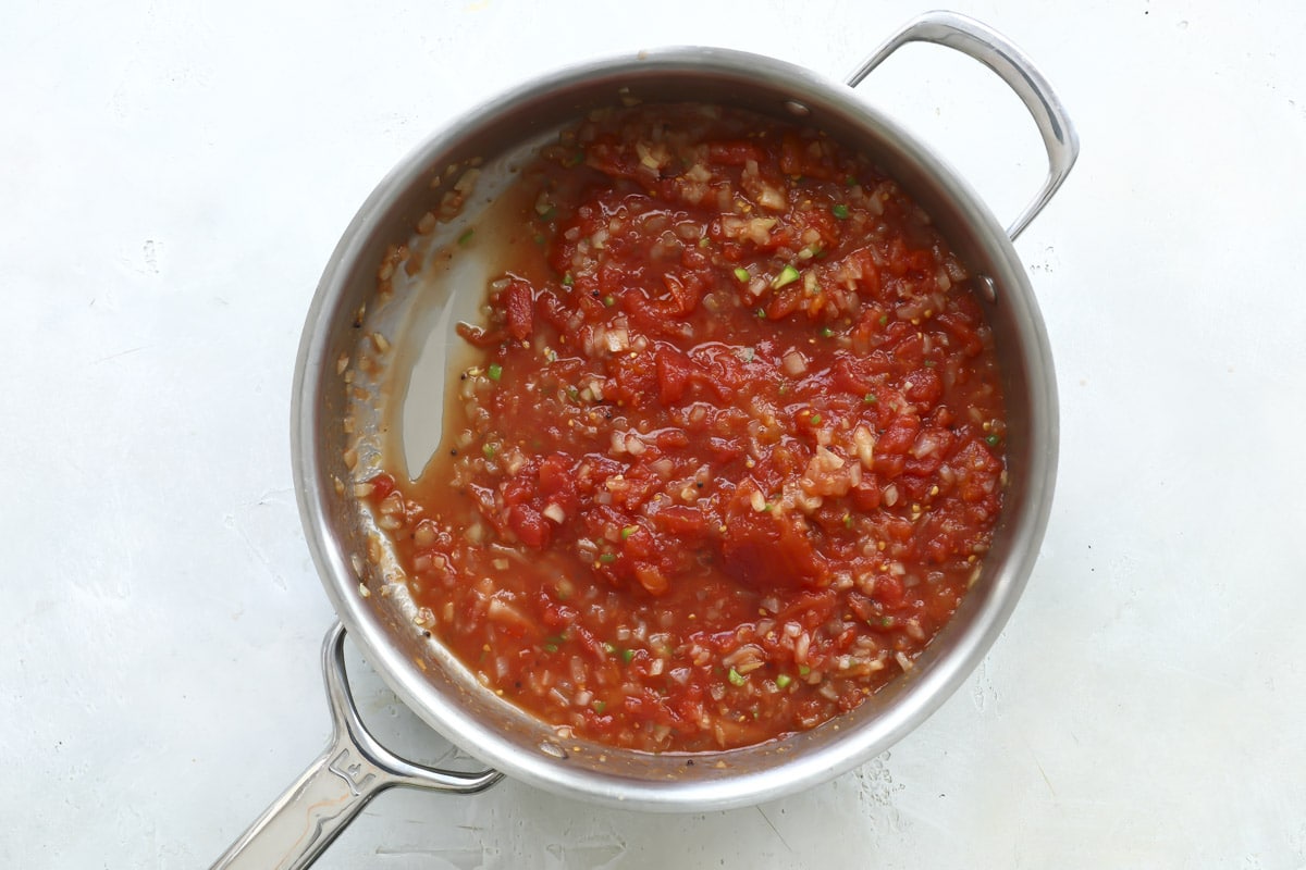 A skillet of smashed tomatoes, onions, and spices.
