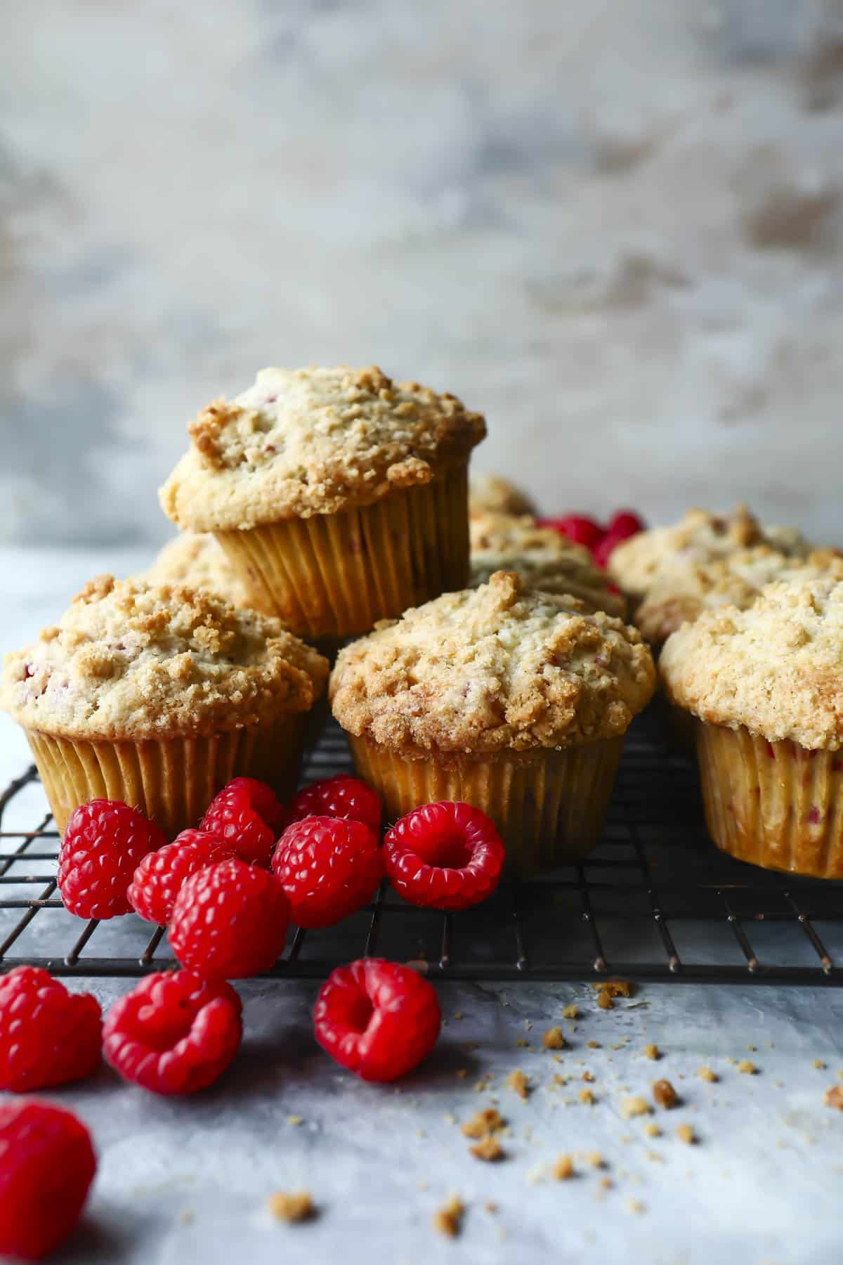 A cooling rack full of raspberry muffins.