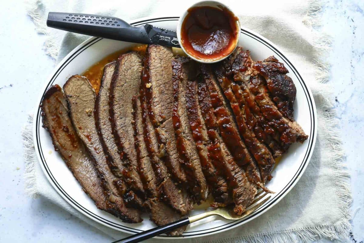 A serving platter with a slow cooker beef brisket slices.