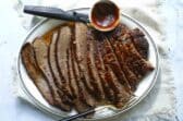 A serving platter with a slow cooker beef brisket slices.