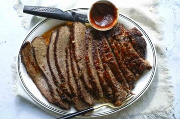 A serving platter with a slow cooker beef brisket slices.