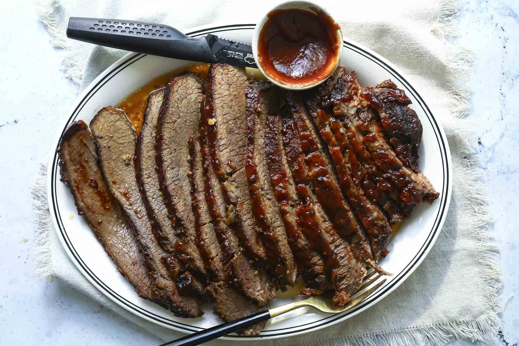 A serving platter with a slow cooker beef brisket slices.