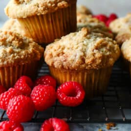 A cooling rack full of raspberry muffins.