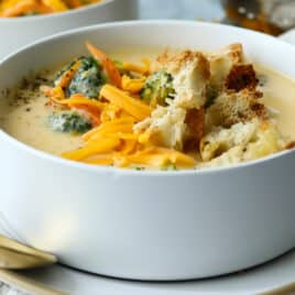 Broccoli cheese soup garnished with croutons and cheese.