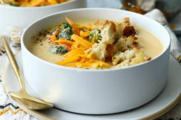 Broccoli cheese soup garnished with croutons and cheese.