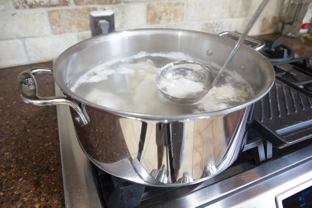 Boiling chicken to make broth for soup.