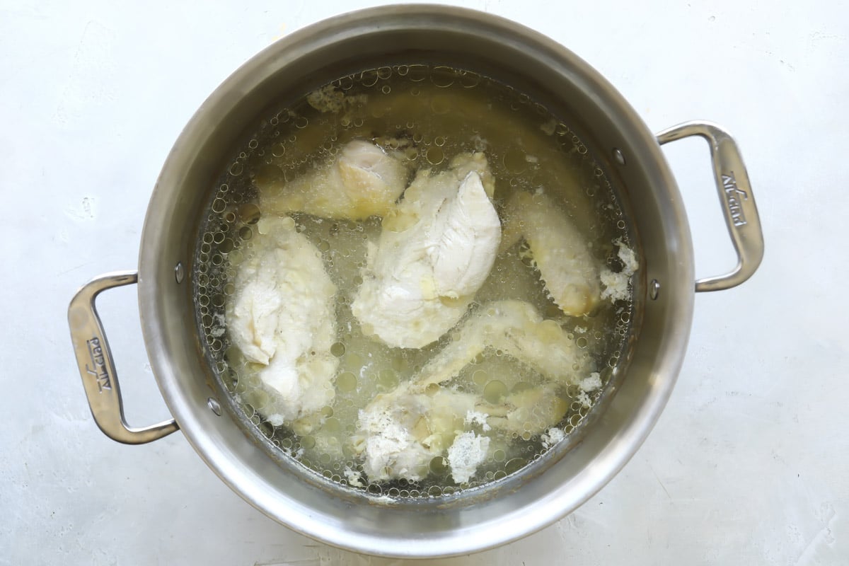 Boiling chicken to make broth for soup.