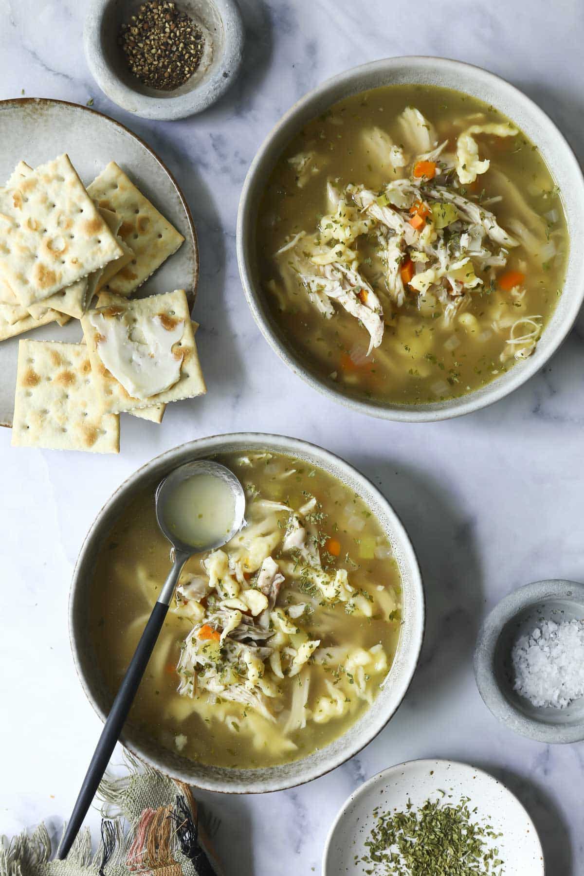 Chicken dumpling soup in two small bowls.