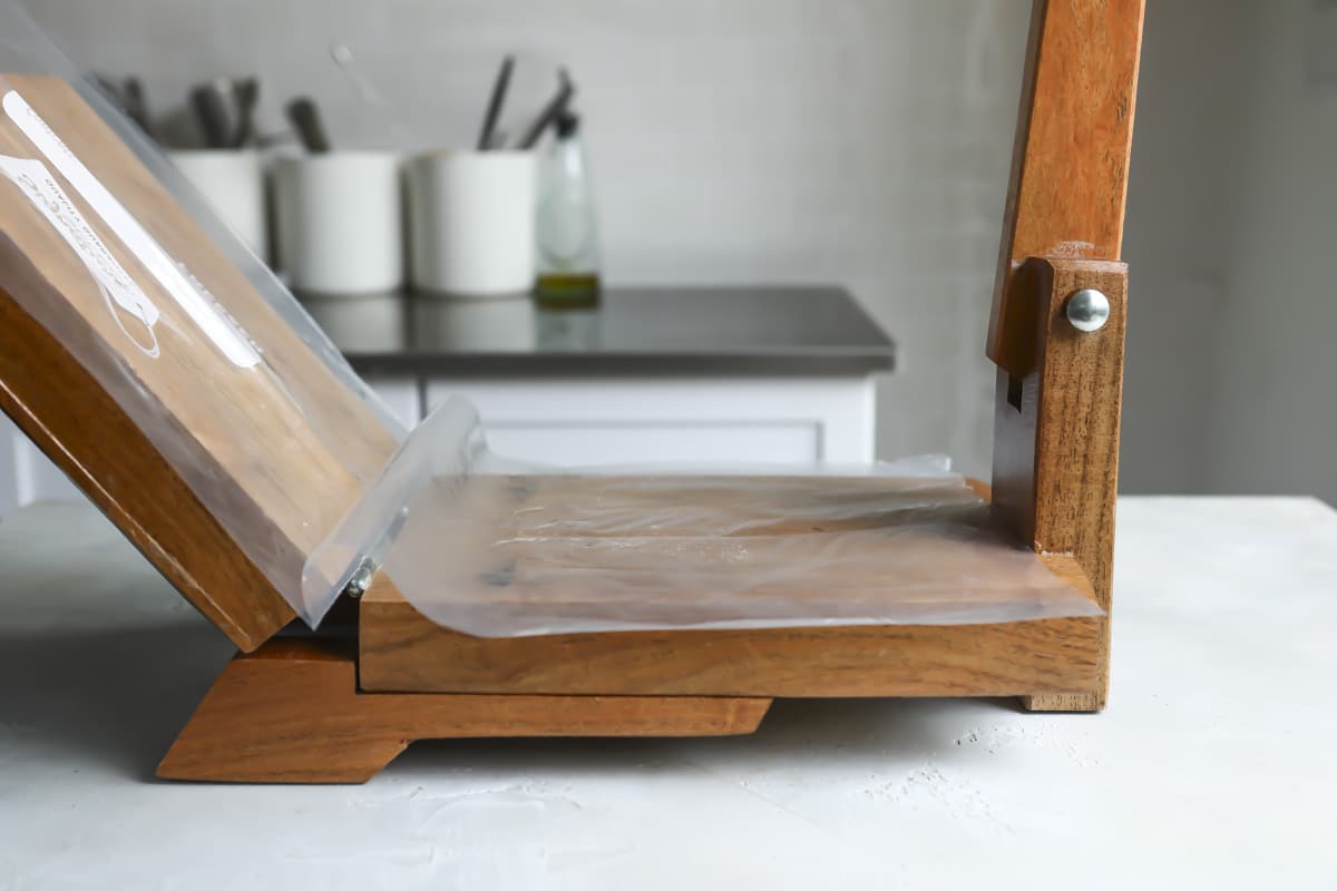 Open tortilla press lined with plastic.