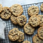 A stack of oatmeal chocolate chip cookies on a cooling rack.