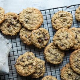A stack of oatmeal chocolate chip cookies on a cooling rack.