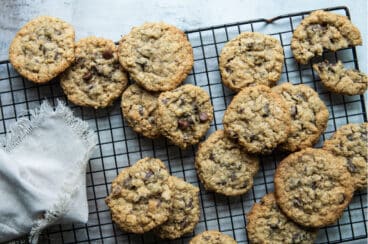 A stack of oatmeal chocolate chip cookies on a cooling rack.