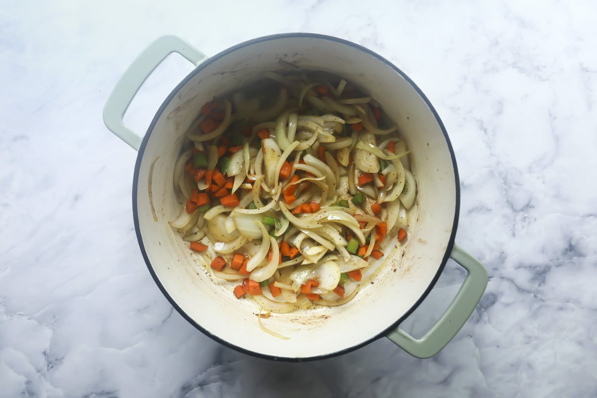 Onions, carrots, and celery cooking in a Dutch oven.