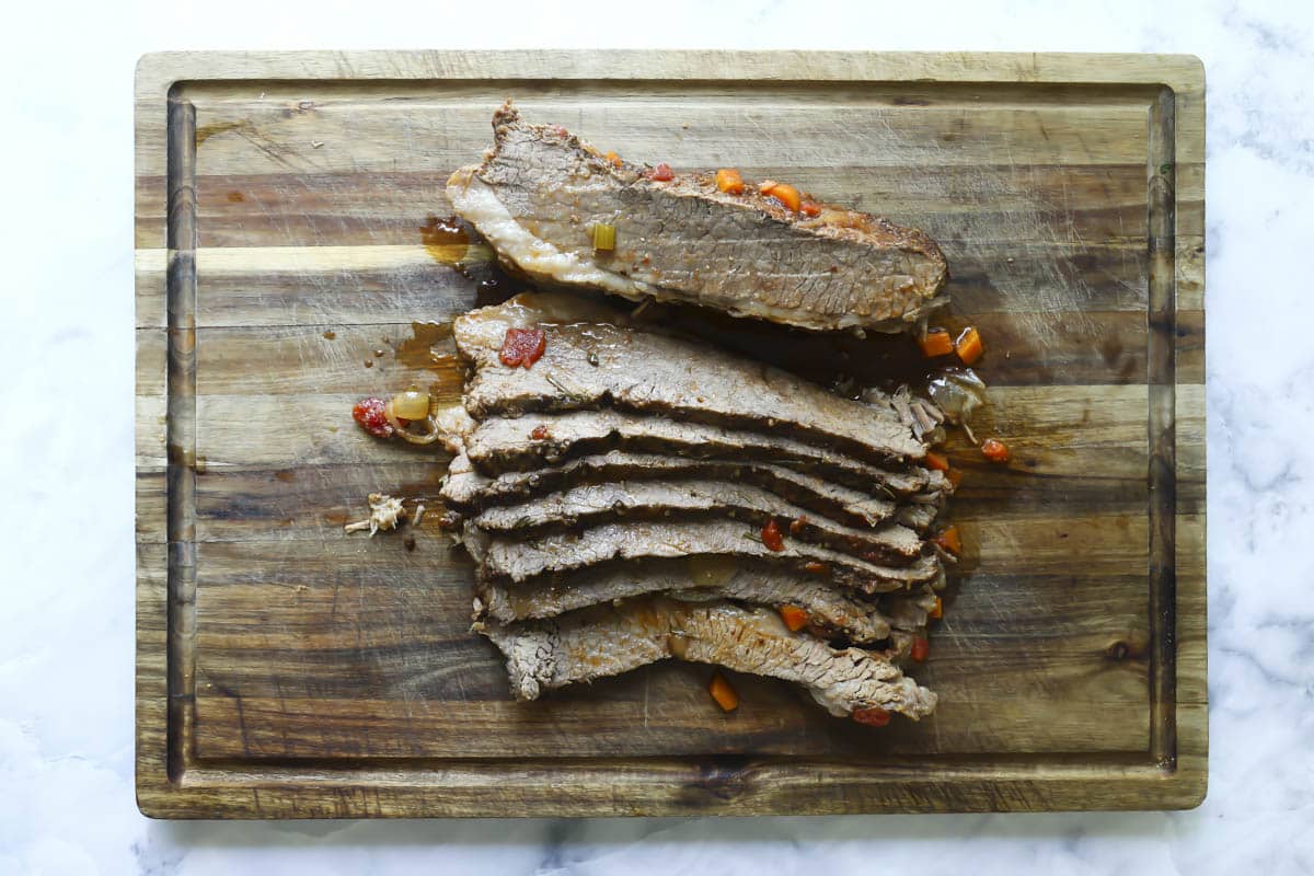 Sliced beef brisket on a cutting board.
