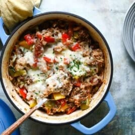 A spoonful of stuffed pepper casserole being scooped out of a Dutch oven.