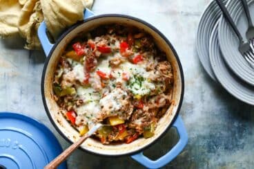 A spoonful of stuffed pepper casserole being scooped out of a Dutch oven.