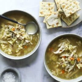 Chicken dumpling soup in two small bowls.