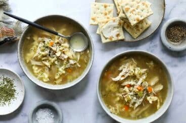 Chicken dumpling soup in two small bowls.