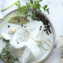 Herbs and spices on cheesecloth to make a Sachet d’Épices.