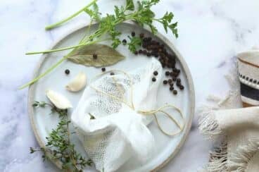 Herbs and spices on cheesecloth to make a Sachet dโรpices.