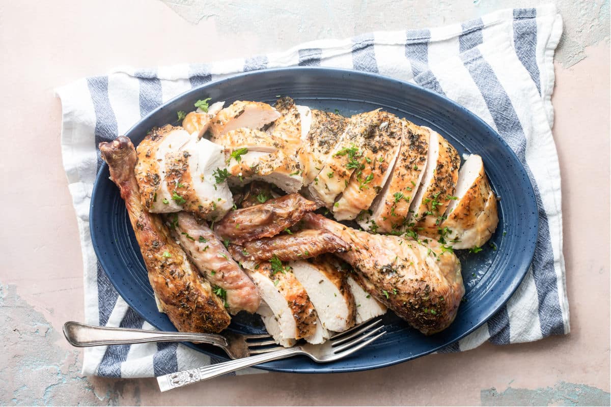 A platter of roasted turkey sliced up.