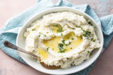 A dish of mashed potatoes with butter on top.