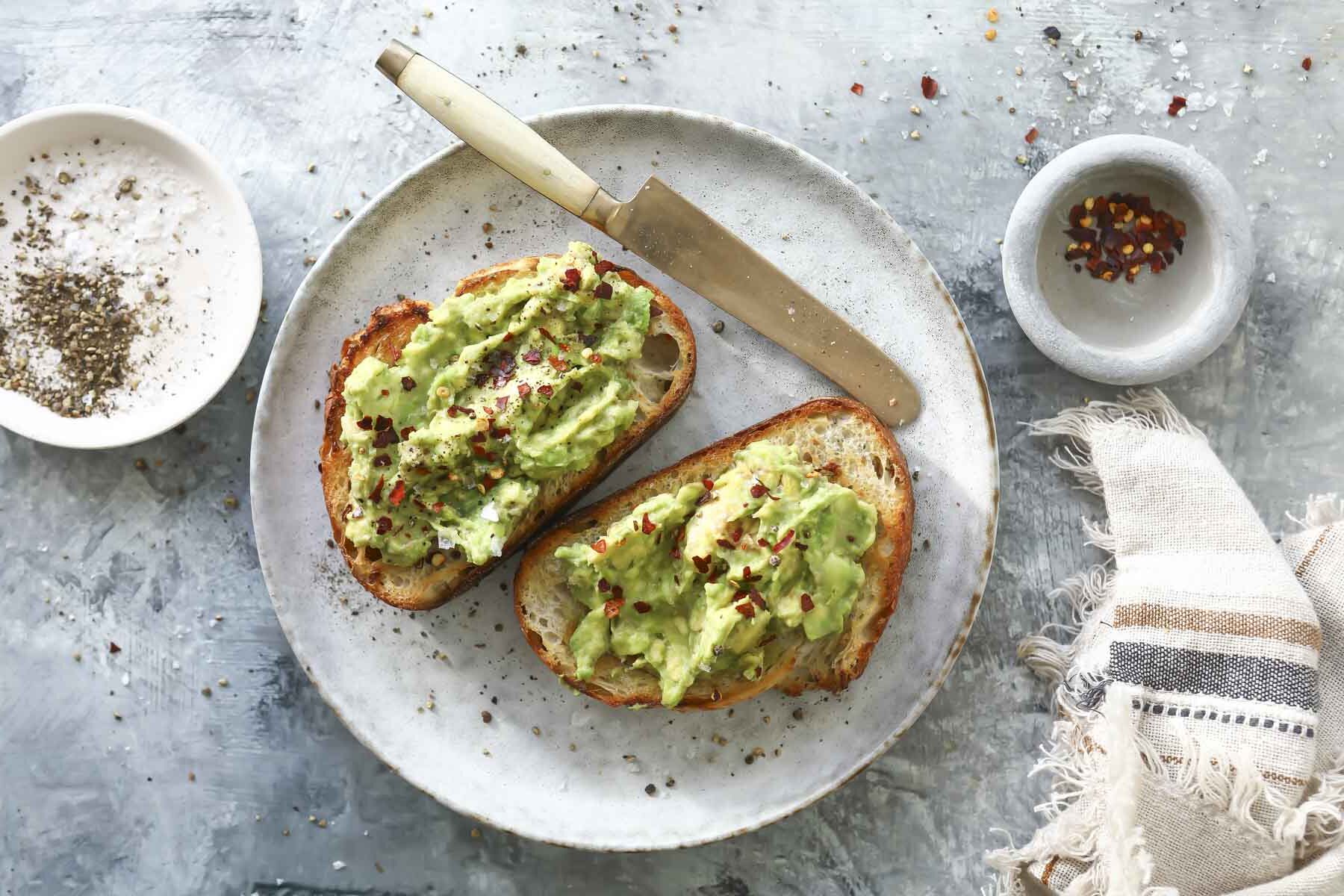 2 slices of toast slathered with mashed avocado and sprinkled with red chili flakes.
