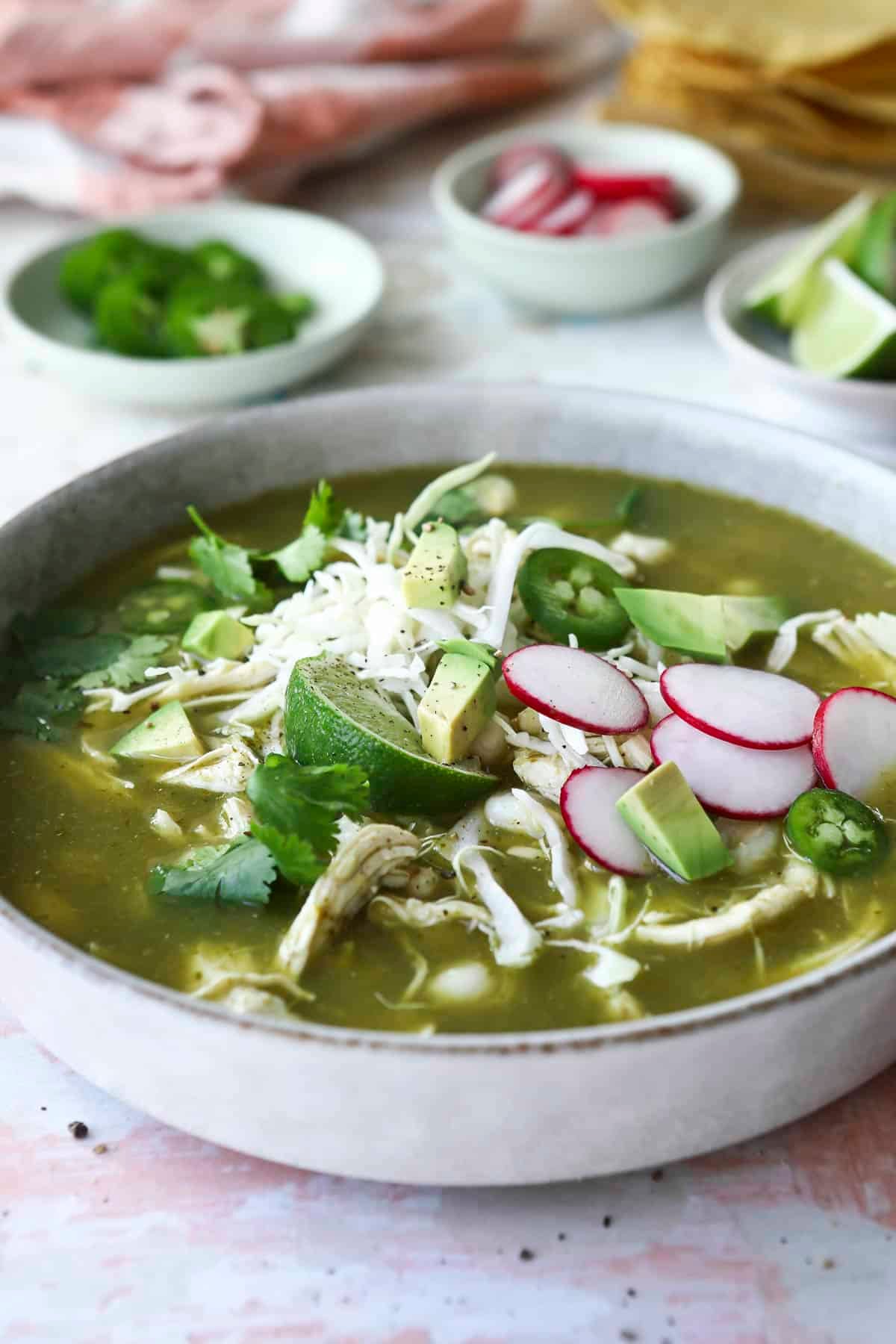 A bowl of pozole verde with toppings.