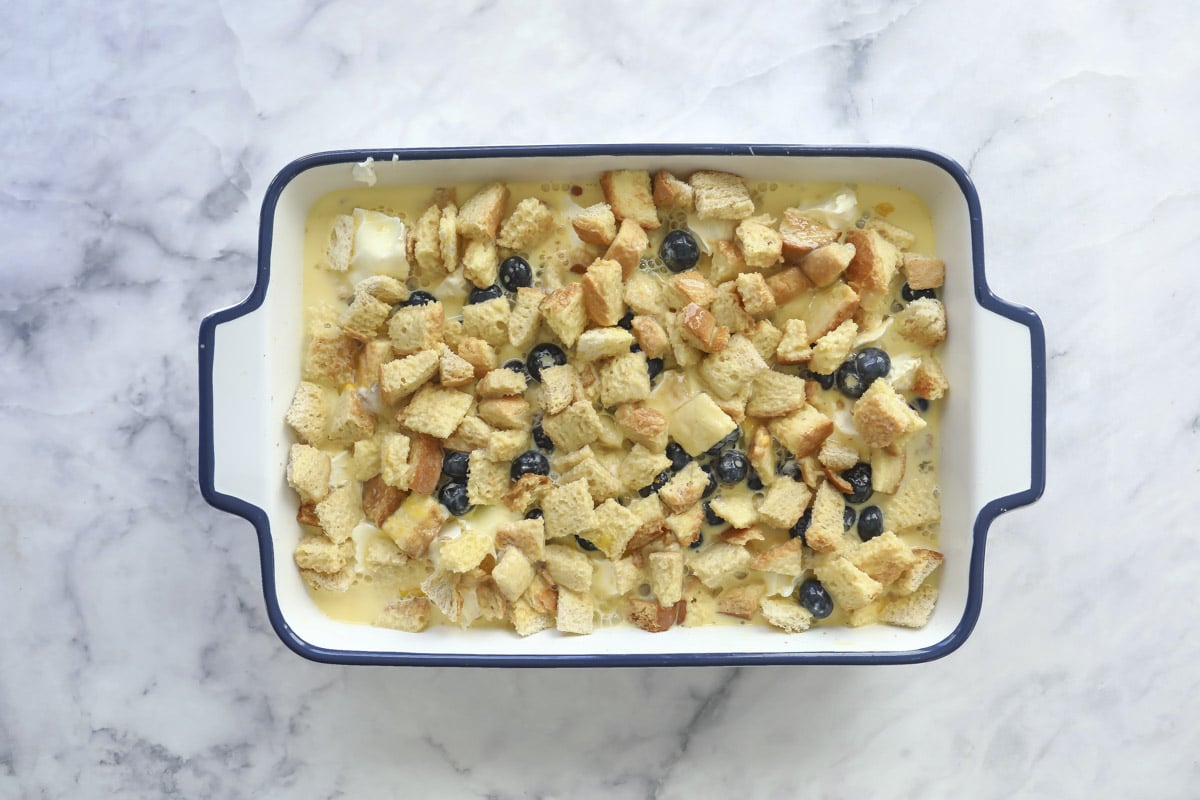 An unbaked dish of blueberry French toast casserole.