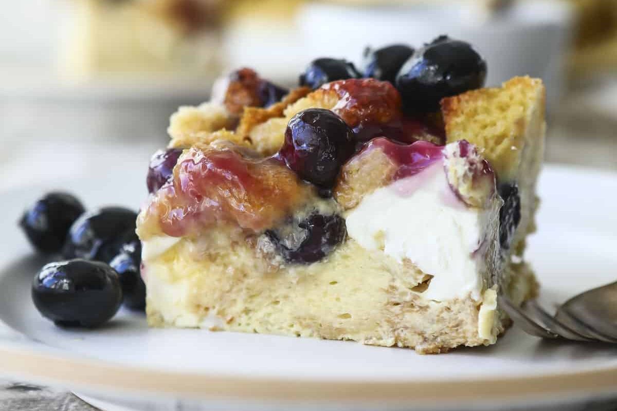 A slice of blueberry French toast casserole with blueberry topping.