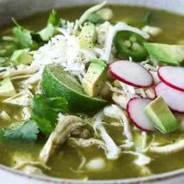 2 bowls of pozole verde with toppings.