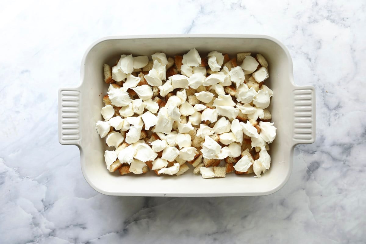Bread cubes in the bottom of a baking dish.
